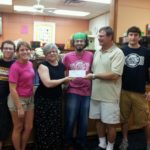 donation to Pyramid Studios Uptown staff and owner Fred Tedio presenting donation to Pyramid Studios