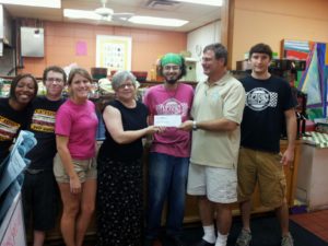 Uptown staff and owner Fred Tedio presenting donation to Pyramid Studios